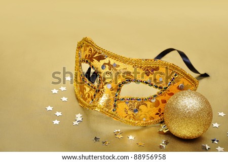 Carnival mask on golden background with silver confetti