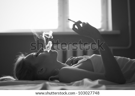 beautiful girl smokes in bed