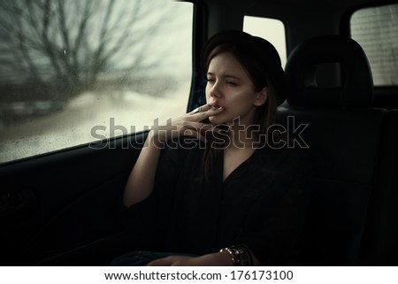 sad hipster girl smokes in the car