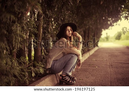 beautiful young woman in hat relaxing in the park