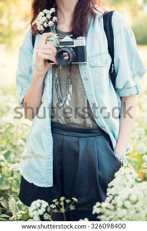 romantic girl photographer in summer park with flowers in their hands
