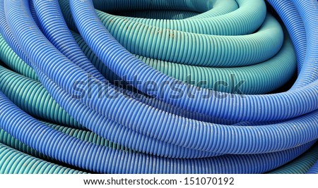 Coil of blue plastic corrugated plumbing pipe in close up