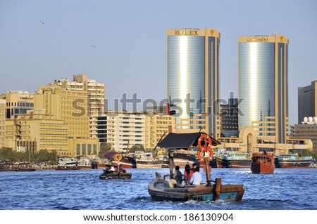 DUBAI, UNITED ARAB EMIRATES - FEBRUARY 8, 2014: A ferry carries passengers across the Dubai creek. At the background is the Deira side of the creek, February 8, 2014 Dubai, United Arab Emirates