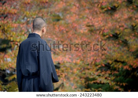 NARA, JAPAN-NOVEMBER 6, 2014; Monk at Kofukuji Temple with leafs at trees in autumn at background.This is an Unesco World Hertige site. November 6, 2014 Nara, Japan