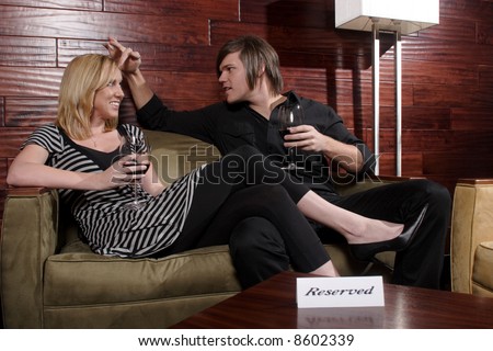 Man and woman laugh during conversation at wine lounge