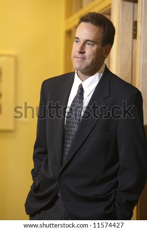 A businessman standing in an office hallway