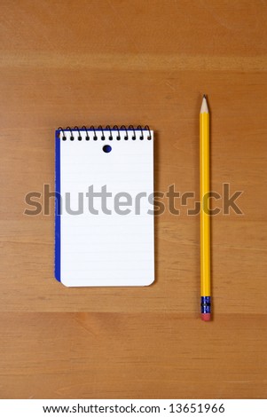 A note pad and pencil on a desk in an office