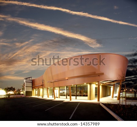 A modern strip mall with the sun setting