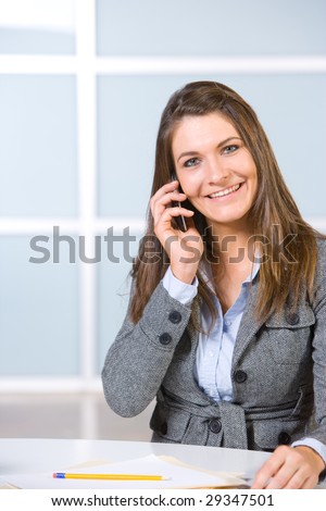 Business woman on a cell phone in a modern office