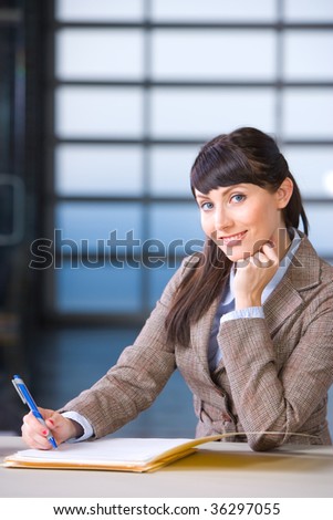Business Woman signing documents in a modern office