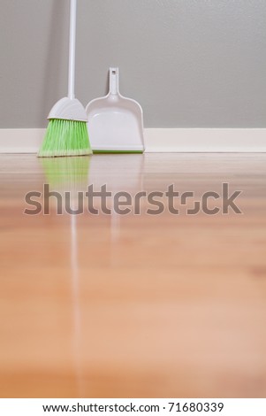 A broom and dust pan on New Hardwood Flooring