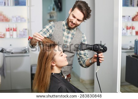 beauty, hairstyle and people concept. Happy young woman and hairdresser