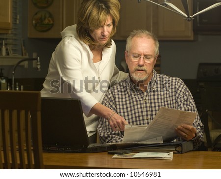 a couple read financial statements at home