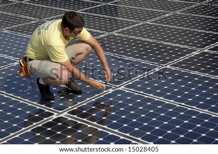 a man connects cables while installing a solar panel