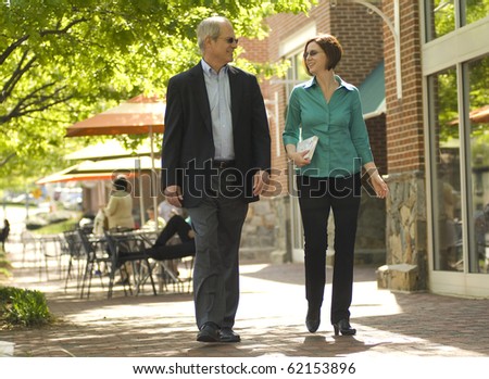 a couple walking through a business area as if on a lunch break