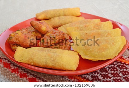 mexican party snacks selection: cajun beef empanadas, chilli beef taquitos, vegetable mexican style wedges on plate.