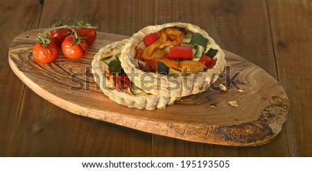 roasted vegetable quiche and tomatoes on wooden board