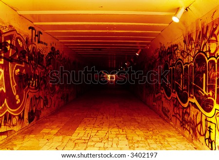 underground tunnel; red, white black colors; blurred figures in background