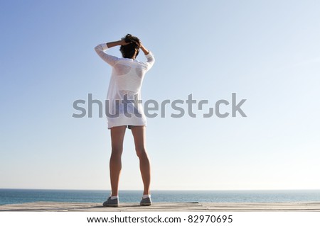 Attractive woman standing back at the beach