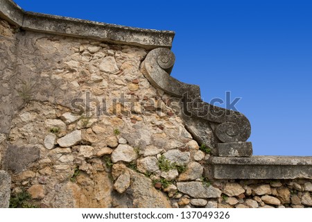 Blue Sky and Stone Wall background / An old country stone wall with a ornament on blue sky
