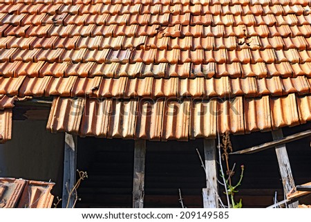 Broken Roof / Detail of a damaged and abandoned roof with broken tiles and beams