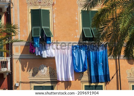 Clothes hanging in Lerici - Liguria - Italy / Sheets and clothes hanging out the window to dry in Lerici typical seaside town in Liguria, La Spezia - Italy