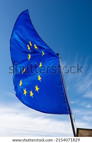 Close-up of an European Union flag waving against a clear blue sky with clouds and copy space. 商業照片 © 