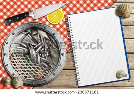 Seafood - Menu Template / Metal porthole with fishing net and fishes, kitchen knife with a slice of lemon, empty notebook and seashells on wooden background with red and white checkered tablecloth