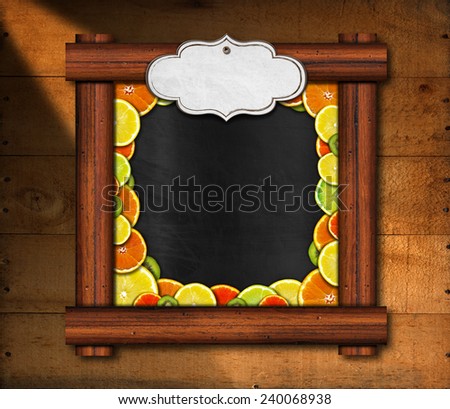 Blackboard with Wooden Frame and Fruit. Blackboard with wooden frame and an empty label with oranges, lemons and kiwi on wooden background