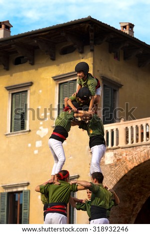 VERONA, ITALY - SEPTEMBER 19, 2015: Tocati, International festival of street games. Castells Performance of Xiquets d\'Alcover of Tarragona, Catalonia, Spain. The Castells (Castle) is a human tower