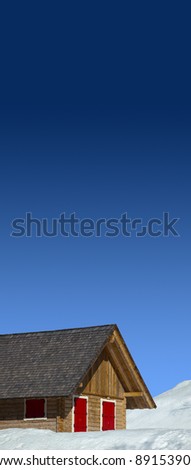 Mountain wood chalet with red windows and blue sky