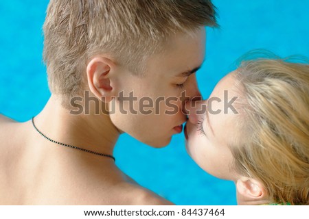 Close-up photo of a couple kissing in a swimming pool