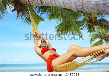 view of nice woman lounging in hammock in tropical environment