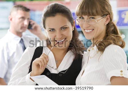 Portrait of young pretty women having  conversation  in office environment