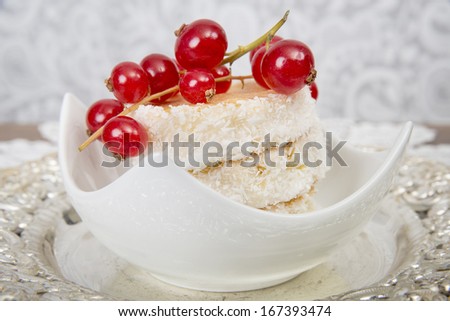 Coconut cake stacked in a bowl decorated with fresh currants