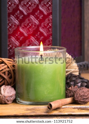 Green candle burning with aromatics
