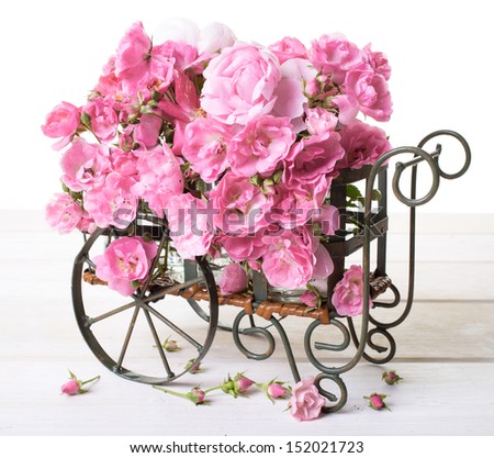 Flower cart full of pink old fashioned roses and peony flowers.