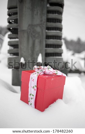 A snow covered old vintage antique tractor and a bright red Christmas gift.  Color isolation. ..... Fine art photography by Edward M. Fielding