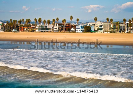 Buildings and palm trees fill the shore line at Venice Beach, CA.