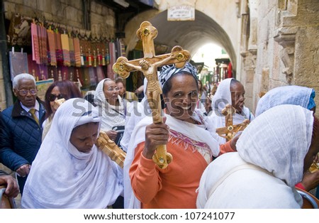 JERUSALEM - APRIL 13 : Ethiopian Christian pilgrims carry across along the Via Dolorosa in Jerusalem on April 13 2012 commemorating the path Jesus carried his cross on the day of his crucifixion
