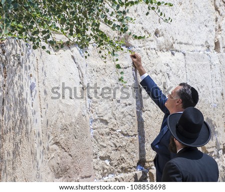 JERUSALEM - JULY 29 :  US Republican presidential candidate Mitt Romney places a mesage written on paper in the stones of the Western wall during his visit to Jerusalem, Israel on July 29, 2012