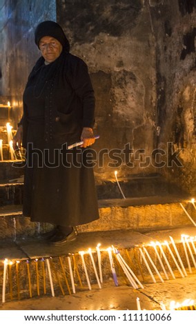 JERUSALEM - AUGUST 25: Unidentified nun prays in the Tomb of Mary in Gethsemane during the feast of the Assumption of the Virgin Mary on August 25, 2012 in old Jerusalem, Israel