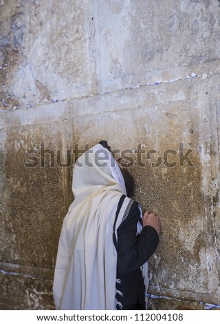 JERUSALEM - JULY 29 : Jewish man prays in the Wailing wall during the Jewish holyday of Tisha B\'av , on July 29 2012 in old Jerusalem , Israel