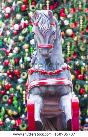 close up on a wooden Rocking Horse with a background of christmas tree and ornaments