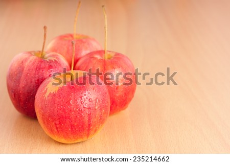 Ripe four red apple on plywood background