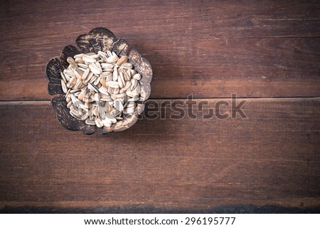 Sunflower seeds in wooden cup on wood background soft tone vintage style