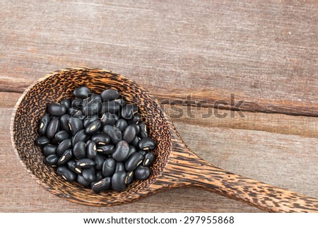 Black bean in wood spoon on wood background