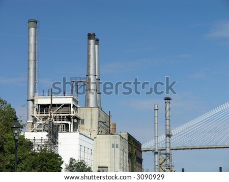 Power Station with exhaust stacks and bridge against blue sky