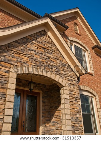 Luxury Model Home Exterior with stone arch entrance