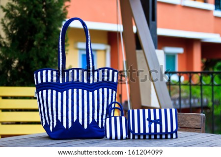 Luxury women bag on table in garden
